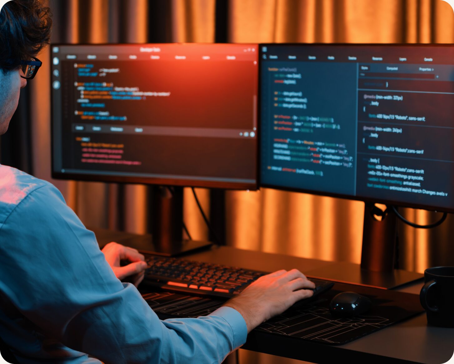 Developer writing code across two monitors