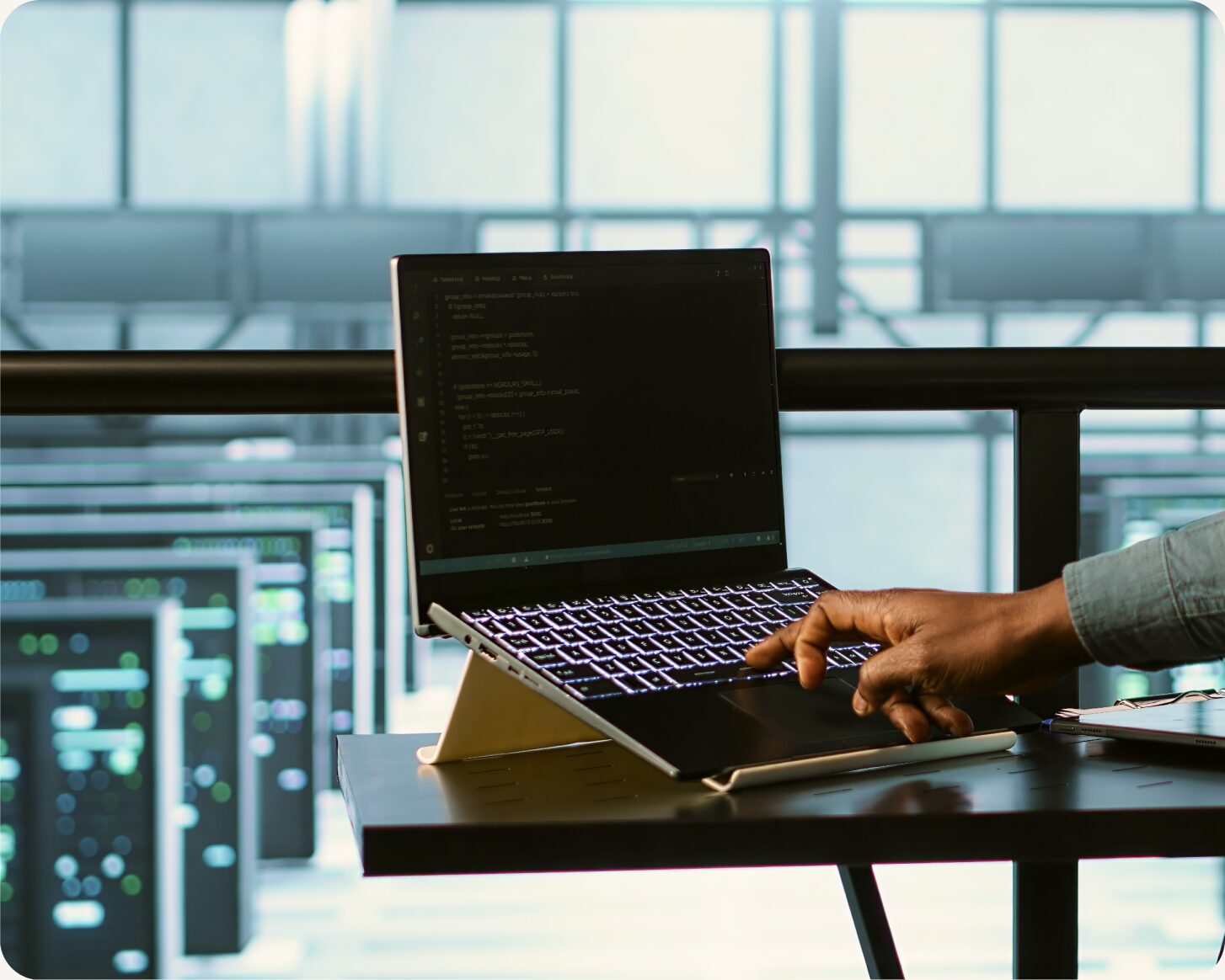 Developer working on a laptop in a server room