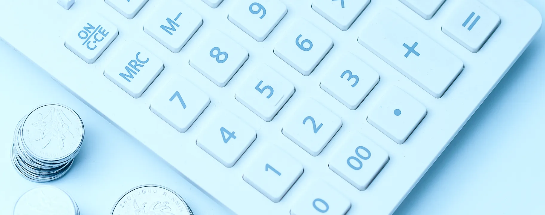 White calculator beside stacks of coins, a notebook and a pen
